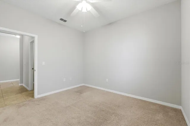 an empty room with a chandelier fan
