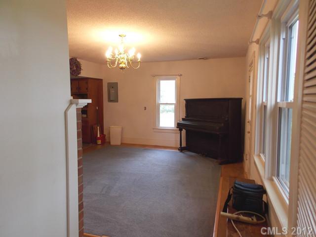 370 Dutchman Road Harmony, NC 28634 - Photo 8 of 11 an empty room with windows hardwood and a kitchen