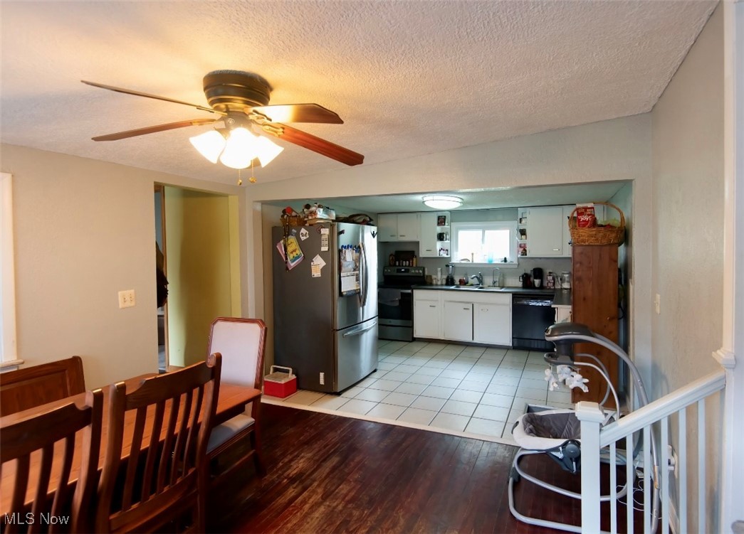 2024 South Newton Falls Road Diamond, OH 44412 - Photo 5 of 17 Kitchen featuring stainless steel appliances, a textured ceiling, dark countertops, light wood finished floors, and a ceiling fan