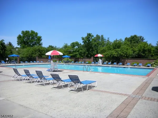 a view of a swimming pool with a patio and a yard