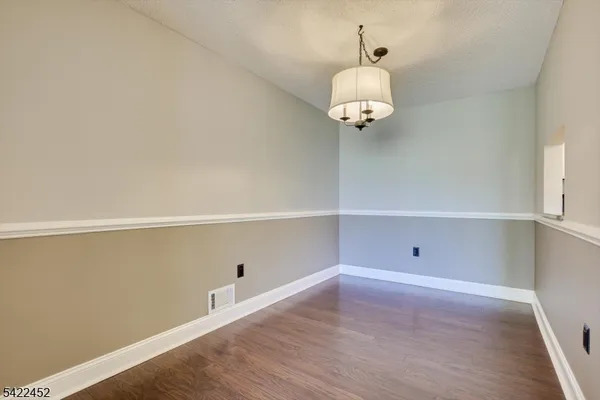 a view of a room with an empty space and wooden floor
