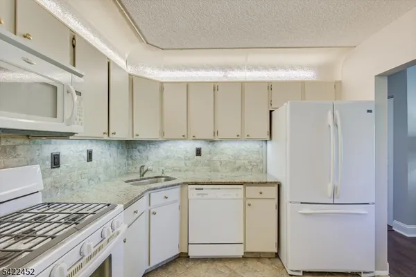 a kitchen with white cabinets and white appliances