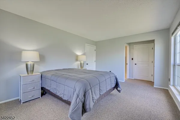 a bedroom with a bed and a lamp on dresser