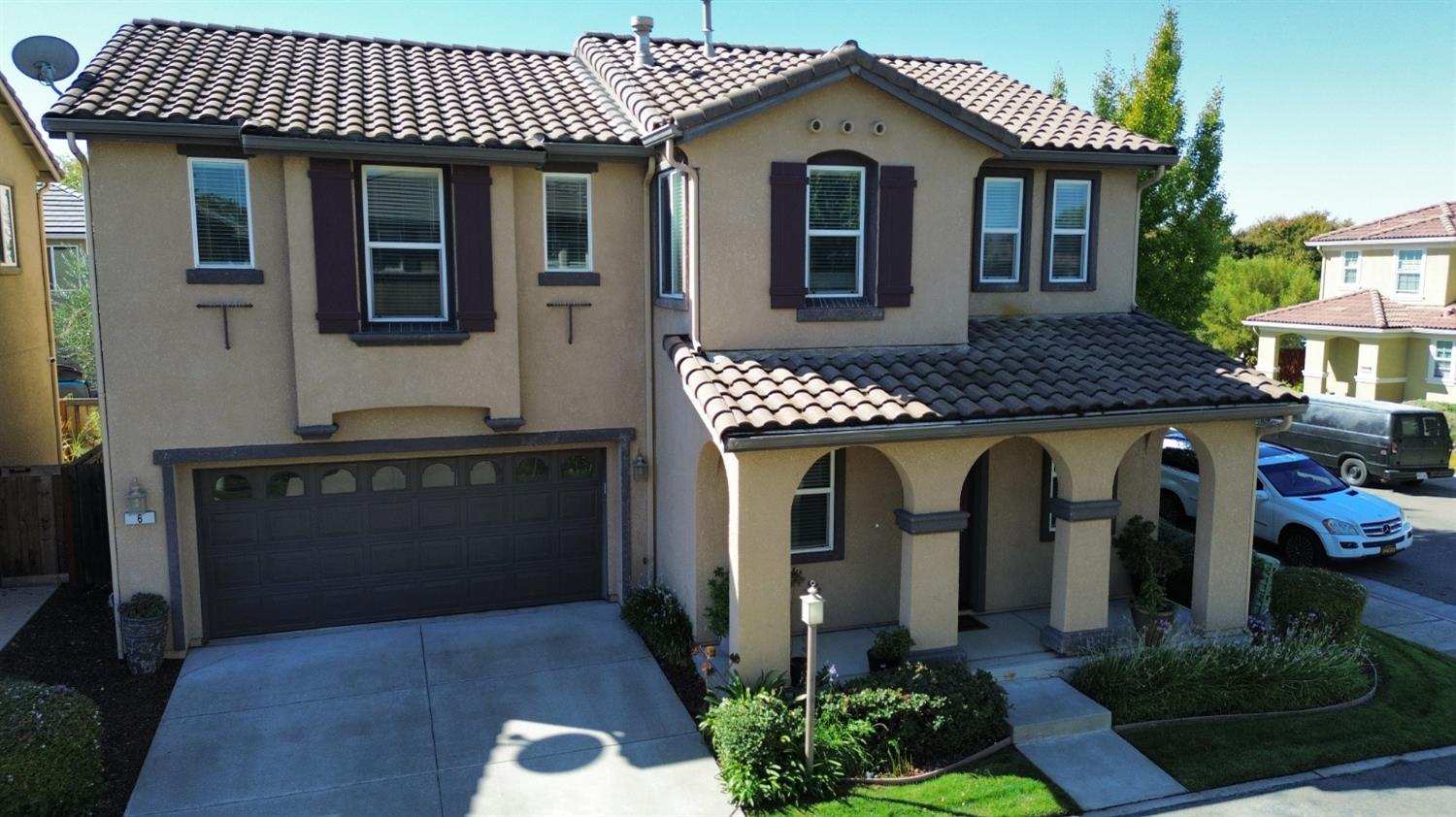 a front view of a house with plants