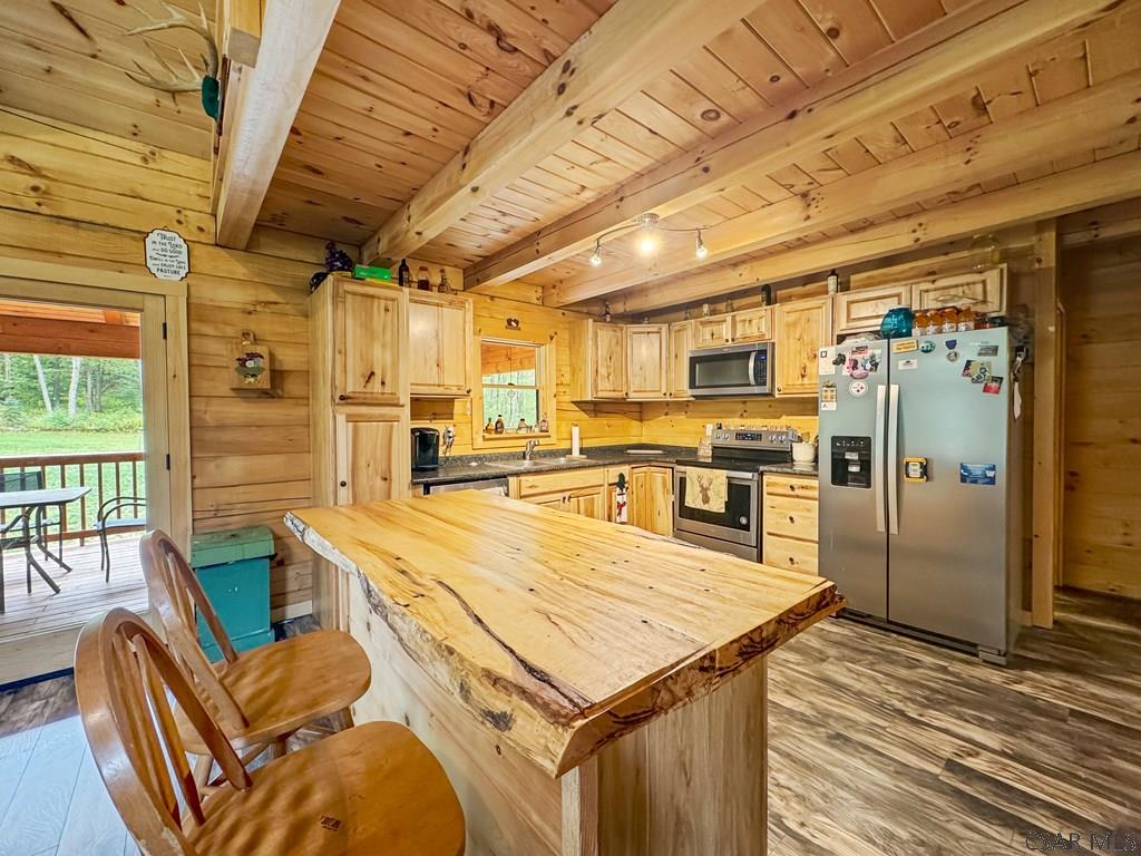 219 Wild Cat Road Windber, PA 15963 - Photo 33 of 63 a kitchen with stainless steel appliances granite countertop a sink a stove top oven a chimney and a refrigerator