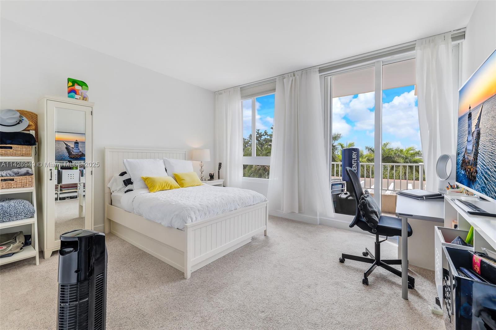 789 Crandon Boulevard, Unit 403 Key Biscayne, FL 33149 - Photo 11 of 27 a bedroom with a bed and a flat tv screen next to a window