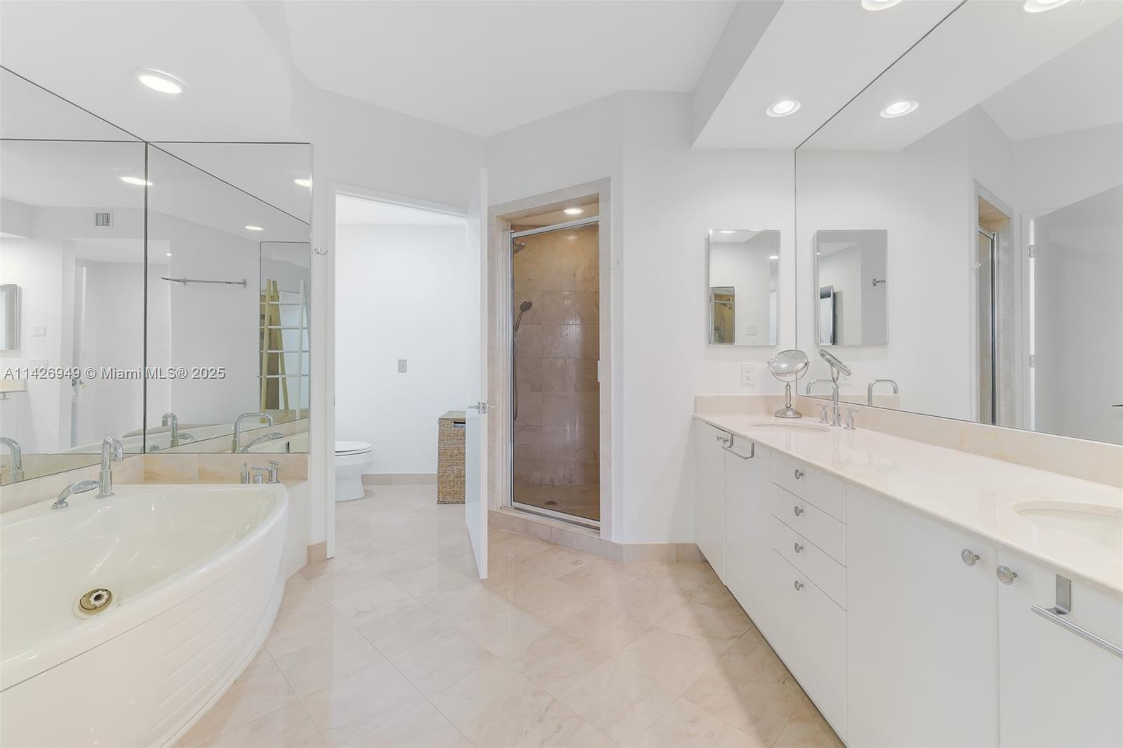 789 Crandon Boulevard, Unit 403 Key Biscayne, FL 33149 - Photo 8 of 27 a bathroom with a tub a sink shower and mirror