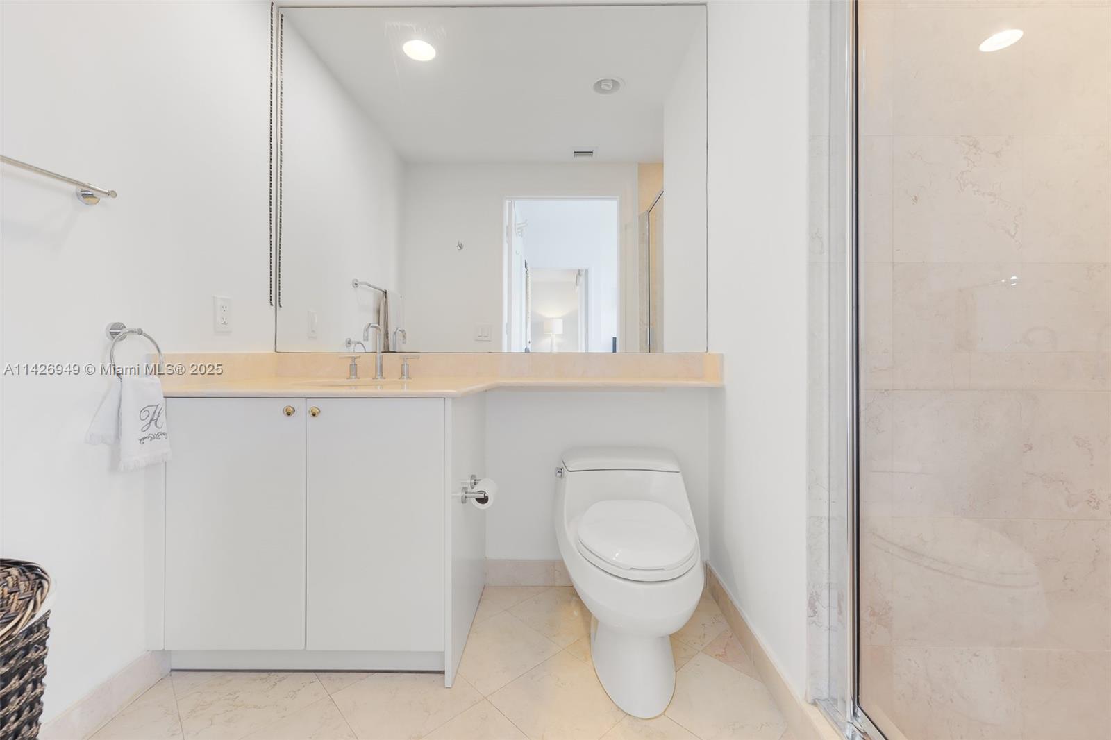 789 Crandon Boulevard, Unit 403 Key Biscayne, FL 33149 - Photo 10 of 27 a bathroom with a toilet sink and mirror