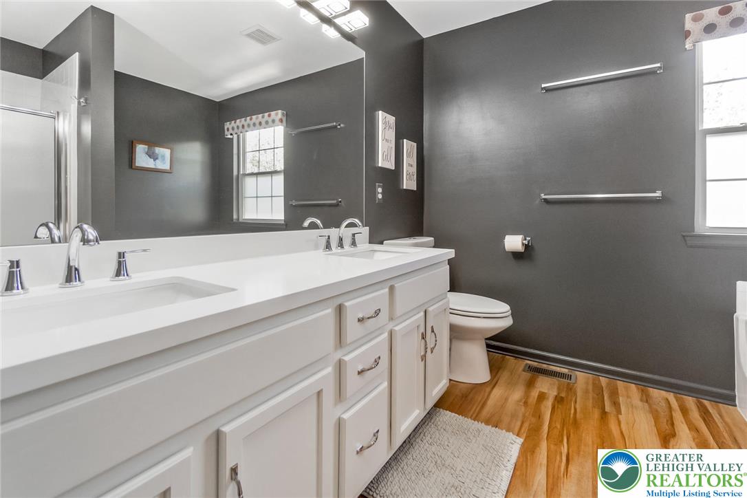 2314 Red Maple Drive Coplay, PA 18037 - Photo 45 of 73 A well-appointed bath features a double vanity and sleek modern finishes on warm wood flooring.