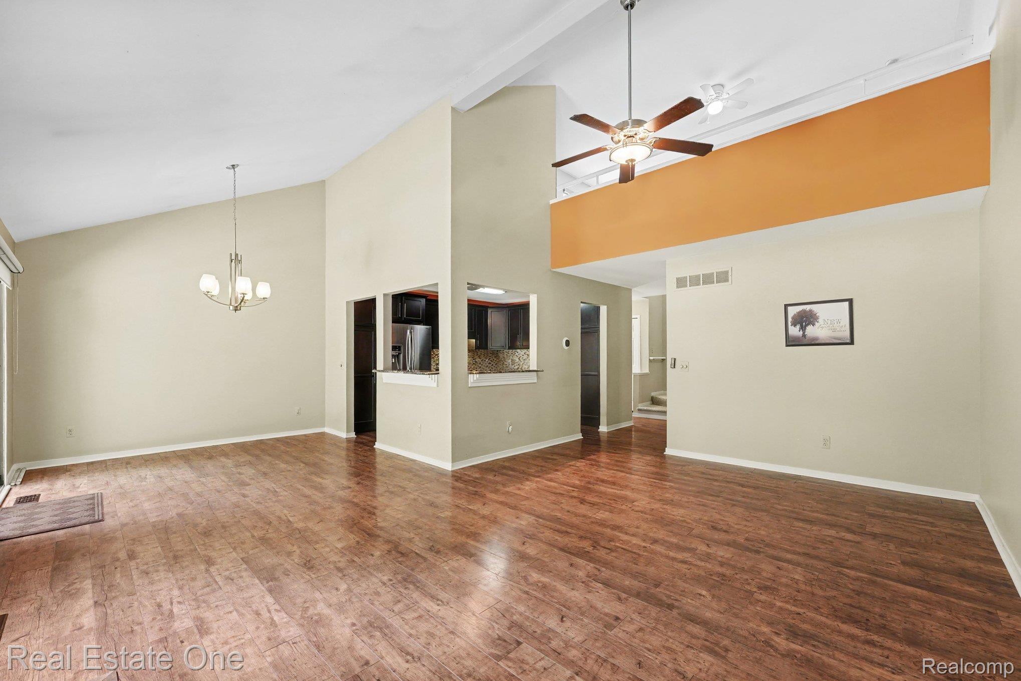 701 Charing Court Rochester, MI 48307 - Photo 6 of 29 Vaulted ceilings featuring wood-finish flooring and a contemporary chandelier