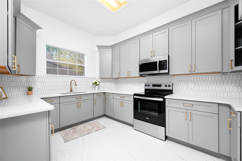 9405 Southwest 31st Lane Gainesville, FL 32608 - Photo 11 of 45 a kitchen with cabinets appliances and a window