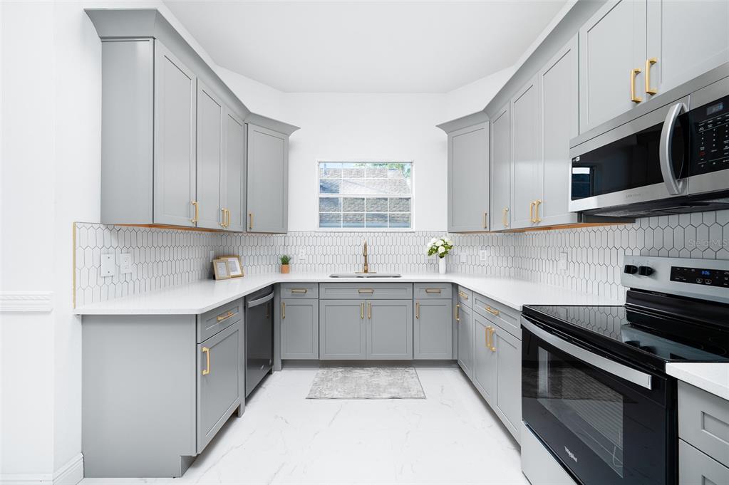 9405 Southwest 31st Lane Gainesville, FL 32608 - Photo 12 of 45 a kitchen with stainless steel appliances granite countertop a sink and a stove