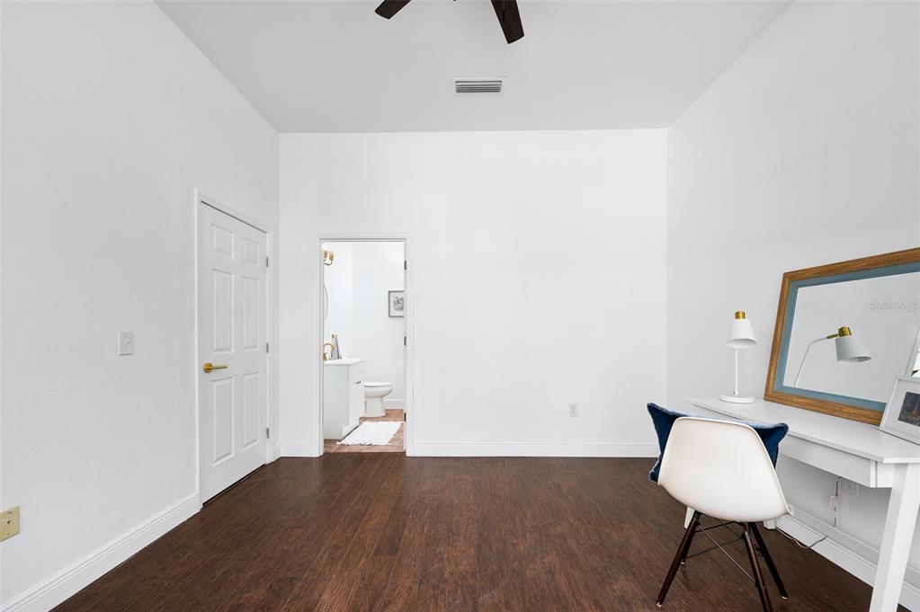 9405 Southwest 31st Lane Gainesville, FL 32608 - Photo 17 of 45 a view of a room with wooden floor a ceiling fan and a window