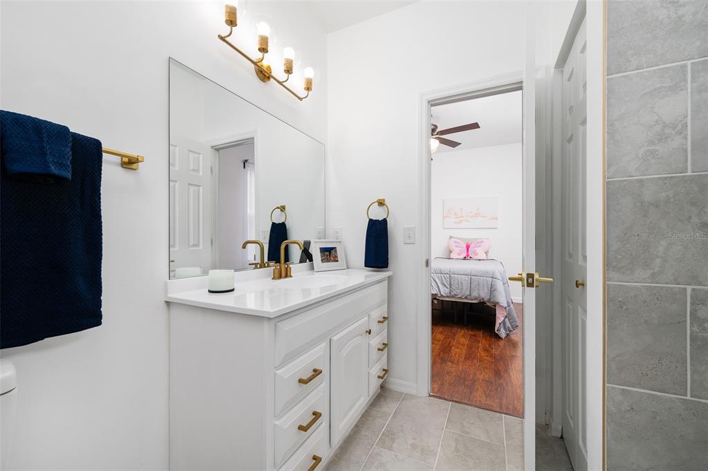 9405 Southwest 31st Lane Gainesville, FL 32608 - Photo 28 of 45 a en suite bathroom with a granite countertop sink and a mirror