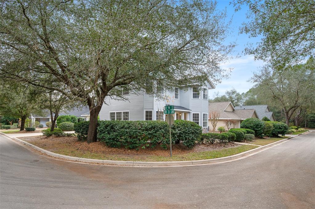 9405 Southwest 31st Lane Gainesville, FL 32608 - Photo 45 of 45 a view of a white house next to a road and trees