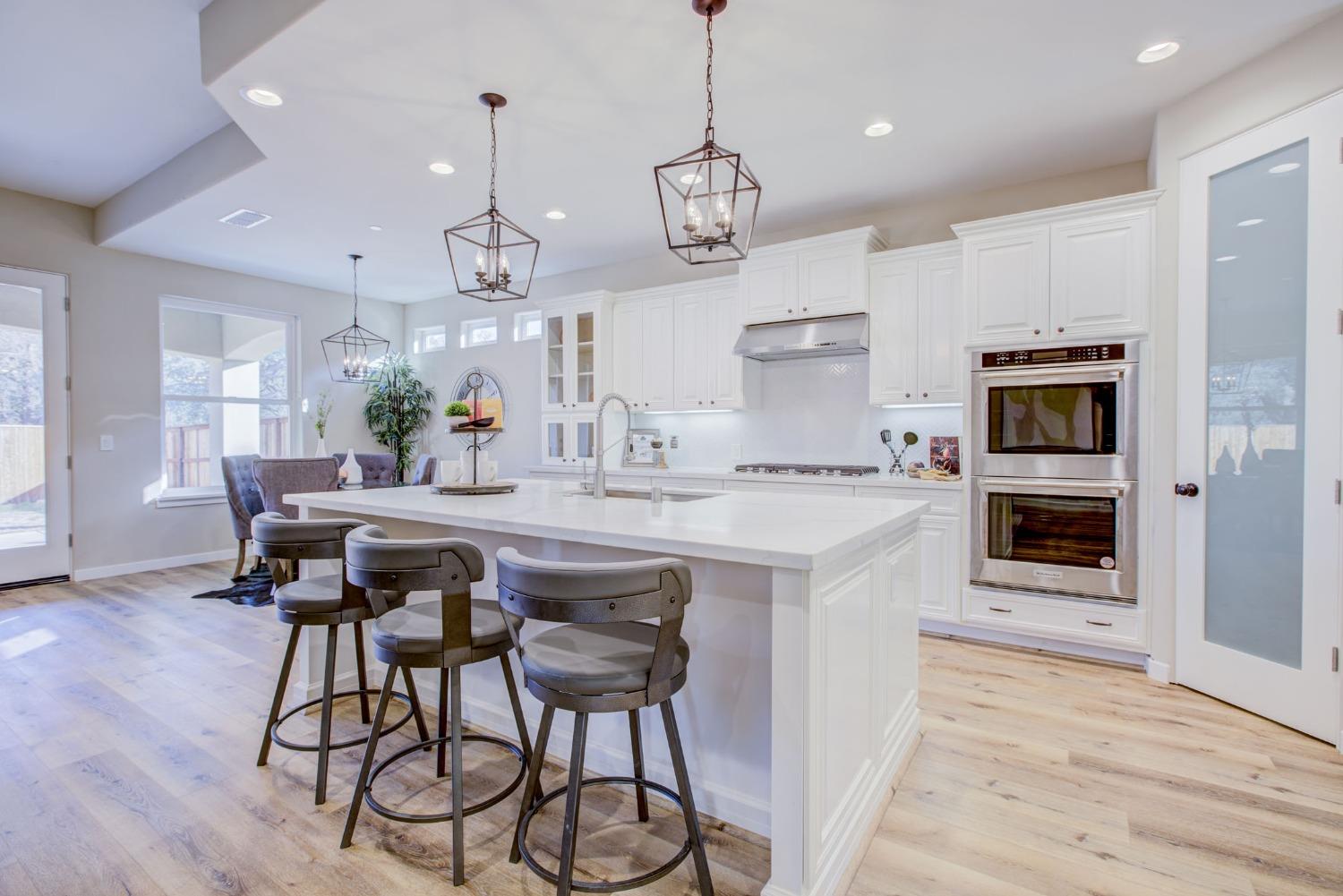 a kitchen with stainless steel appliances kitchen island a large island in the center cabinets and wooden floor