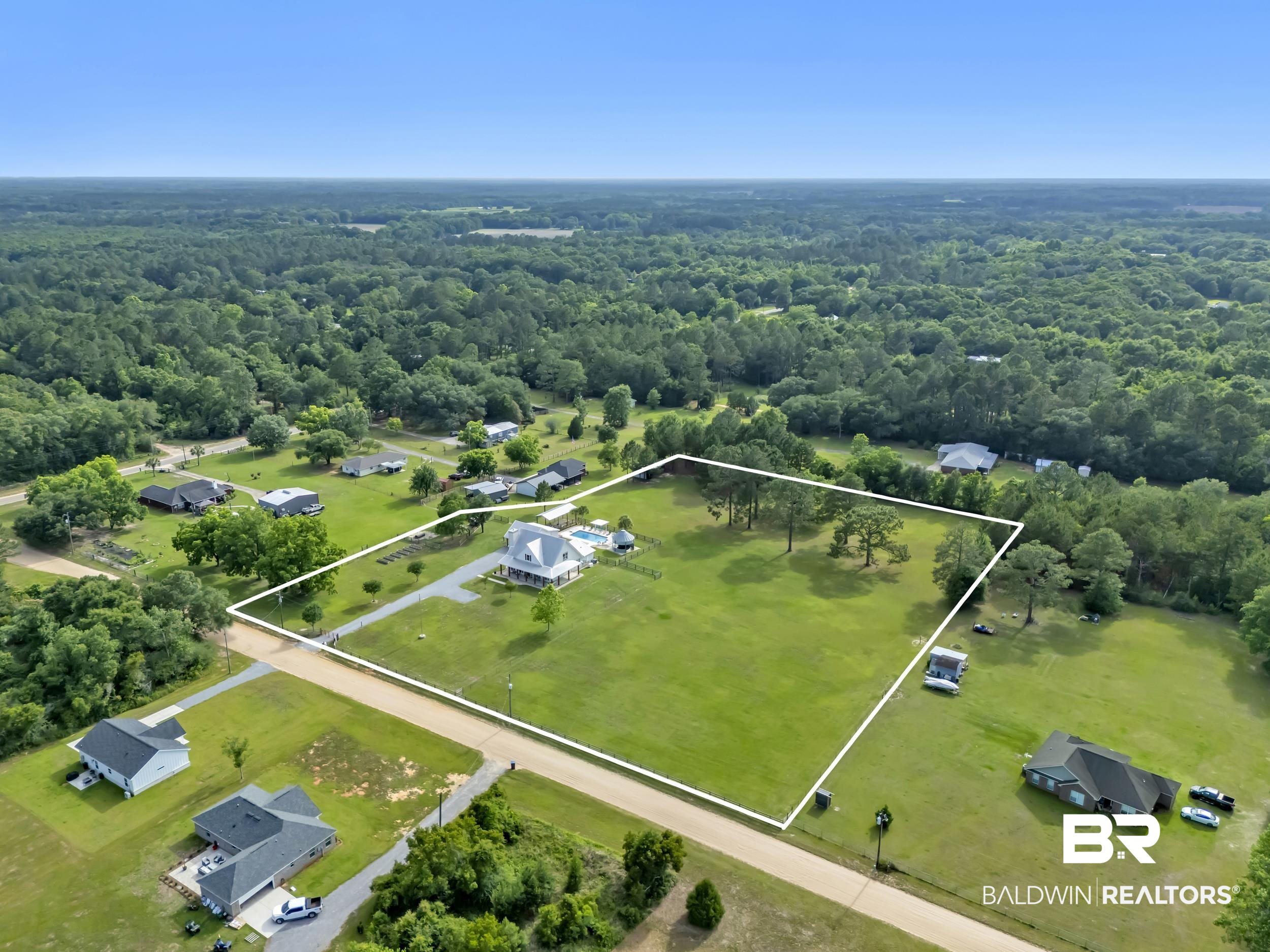 6576 Ranch Loop Road East Grand Bay, AL 36541 - Photo 33 of 39 Expansive property featuring a large main residence with a prominent porch, a private swimming pool, mature trees, and a substantial grassy area