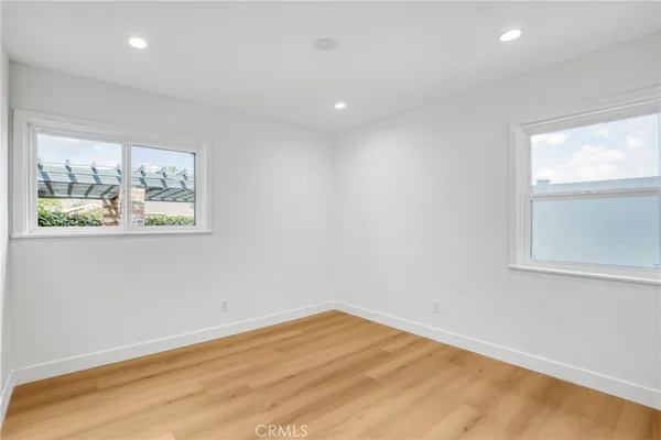 a view of empty room with window and wooden floor