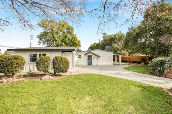 a front view of a house with a yard and potted plants