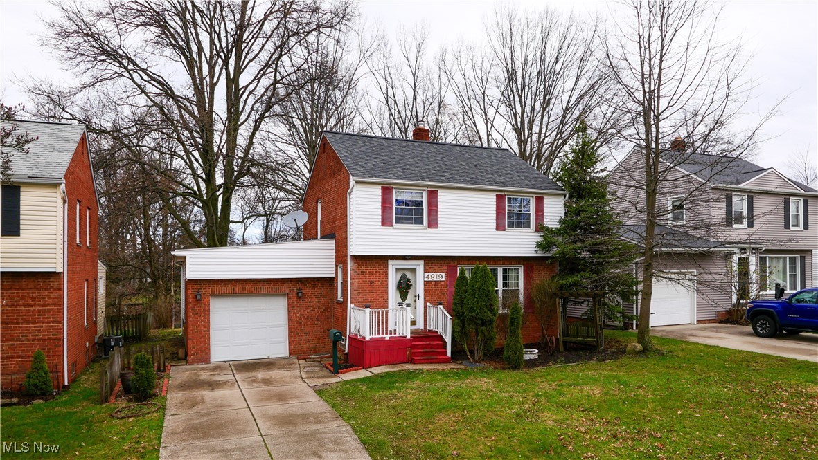 4819 Westbourne Road Cleveland, OH 44124 - Photo 2 of 39 Colonial-style house featuring driveway, a front lawn, brick siding, a garage, and a chimney