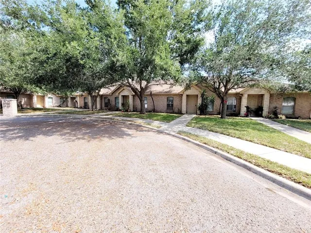 a front view of a house with a yard and trees