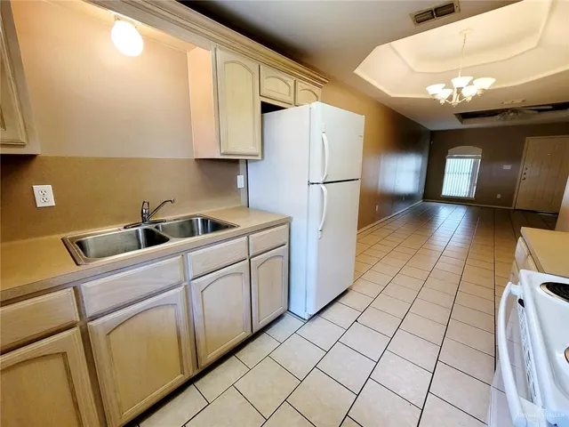 a kitchen with a sink a refrigerator and cabinets