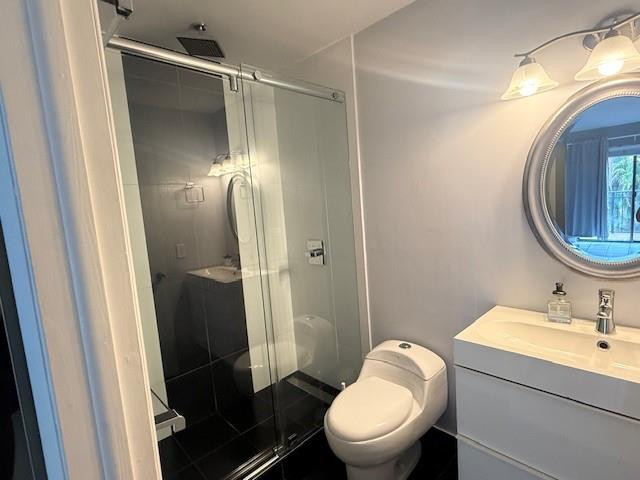 10525 Southwest 153rd Court, Unit 4 Miami, FL 33196 - Photo 22 of 33 a bathroom with a toilet sink vanity and shower