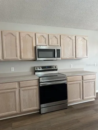 a kitchen with stainless steel appliances granite countertop a stove microwave and sink