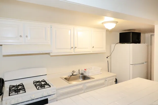 a kitchen with a sink a stove and cabinets
