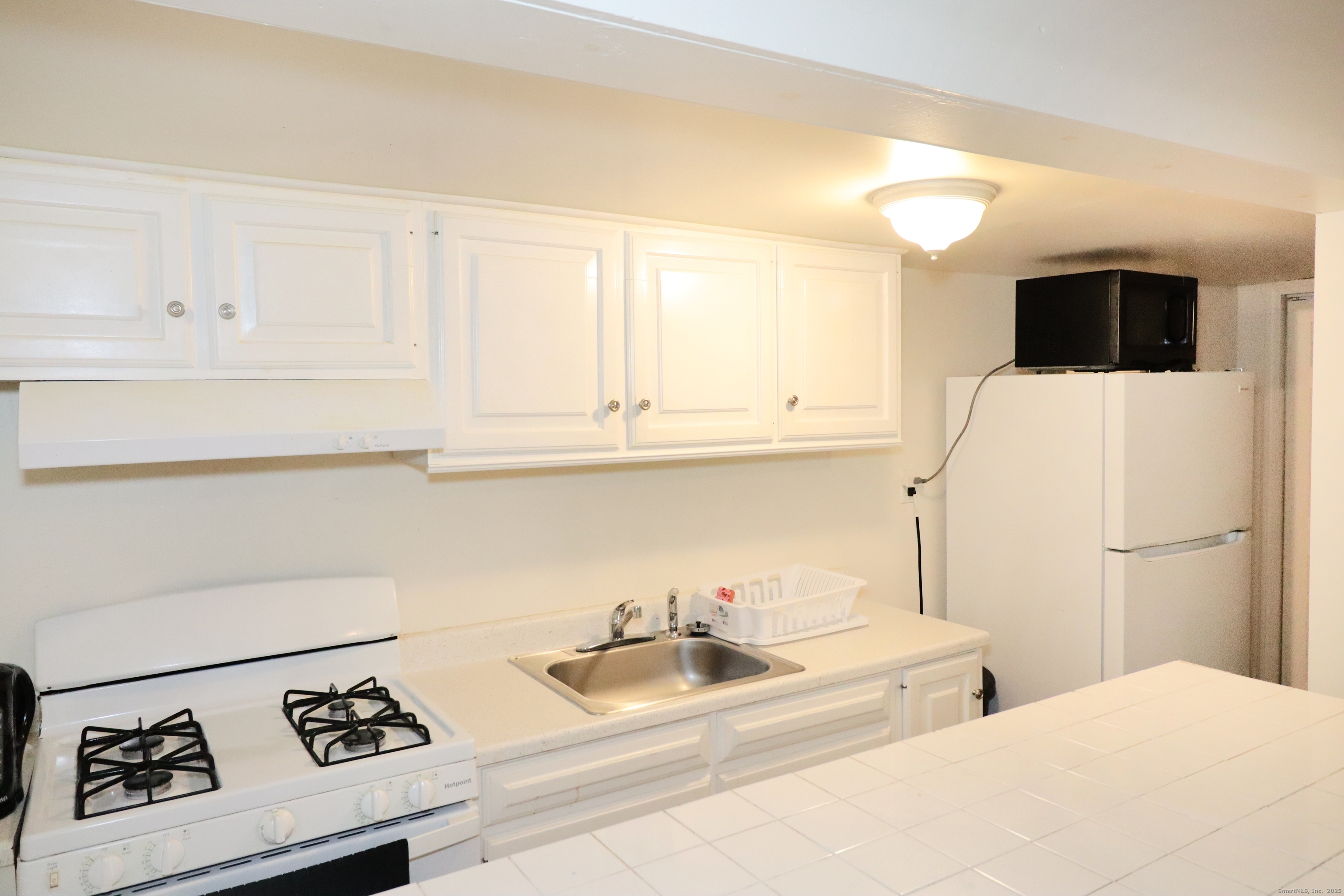 60 Olive Street Bridgeport, CT 06605 - Photo 14 of 34 a kitchen with a sink a stove and cabinets