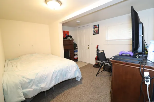 a bedroom with a bed and a flat tv screen on dresser