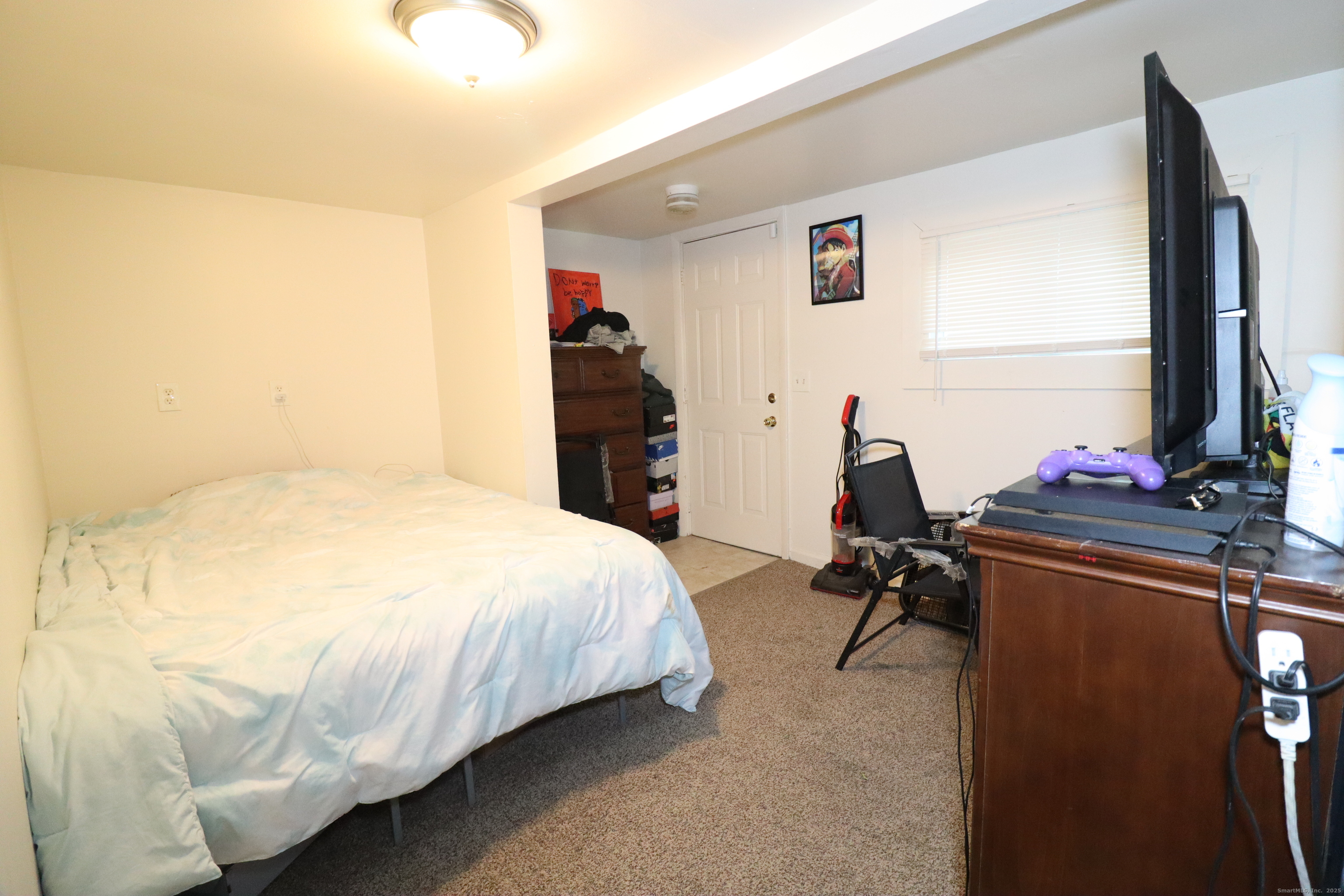 60 Olive Street Bridgeport, CT 06605 - Photo 17 of 34 a bedroom with a bed and a flat tv screen on dresser