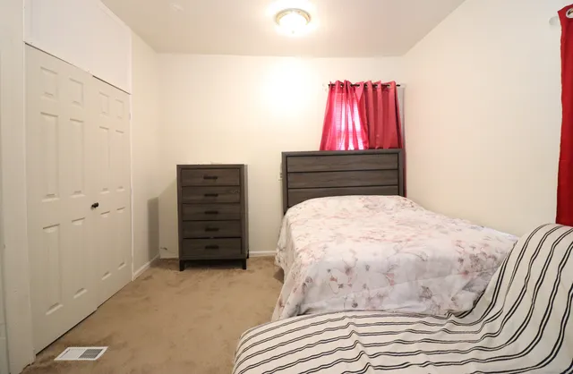 a bedroom with a bed and a dresser