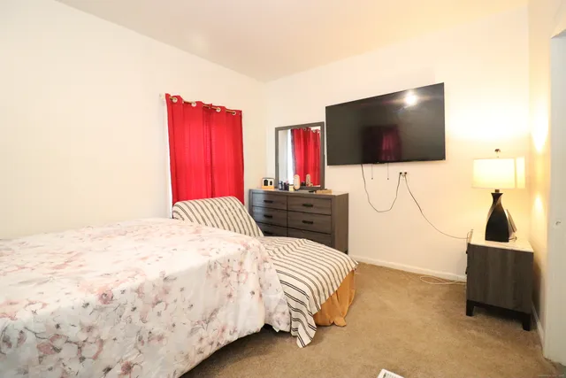 a bedroom with a bed and a flat screen tv