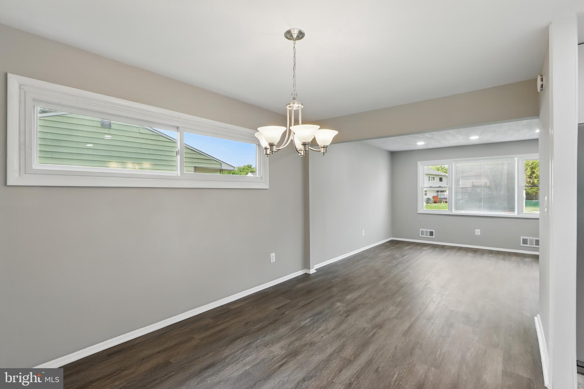 9021 Meadow Heights Road Randallstown, MD 21133 - Photo 12 of 41 a view of a room with wooden floor chandelier and windows