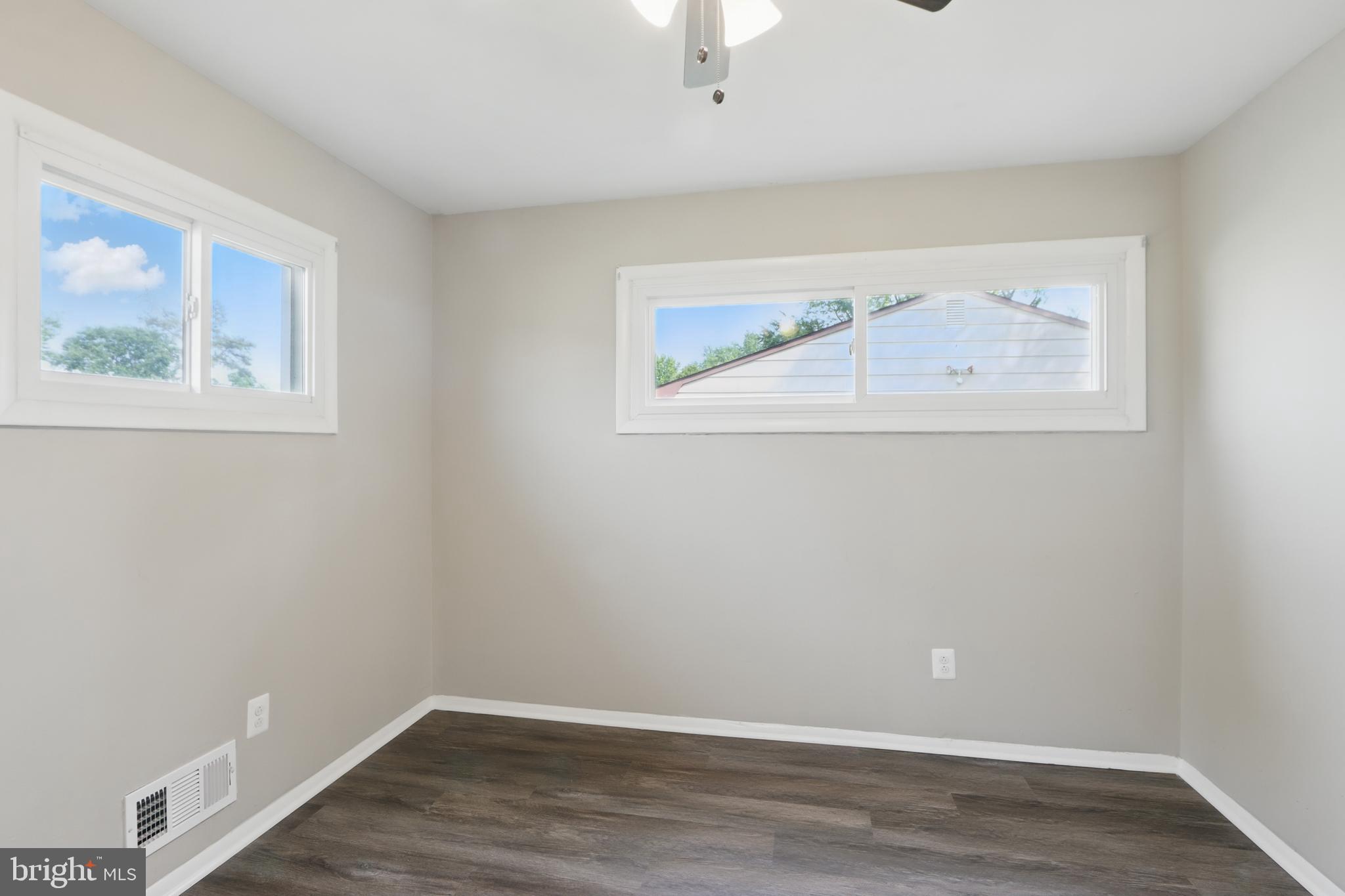 9021 Meadow Heights Road Randallstown, MD 21133 - Photo 22 of 41 an empty room with a window and wooden floor
