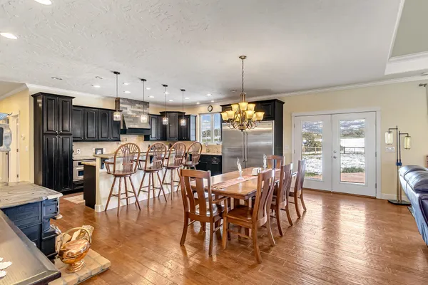 a view of a dining room and livingroom with furniture wooden floor a chandelier