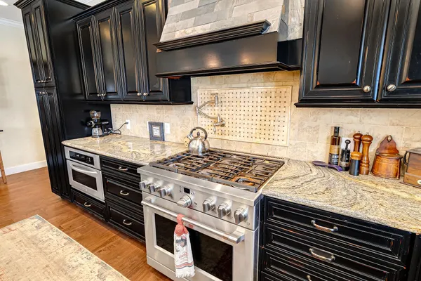 a kitchen with granite countertop a stove and a sink