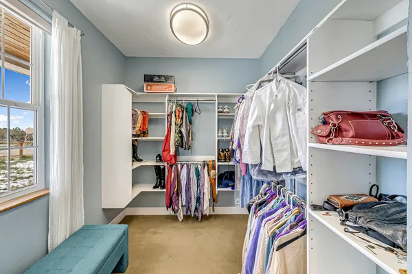 a view of walk in closet with clothes and shoes