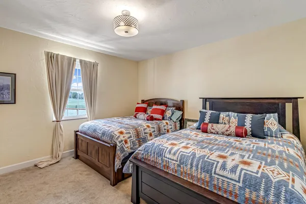a bedroom with two beds and a large window
