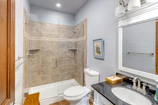a bathroom with a sink a toilet and shower