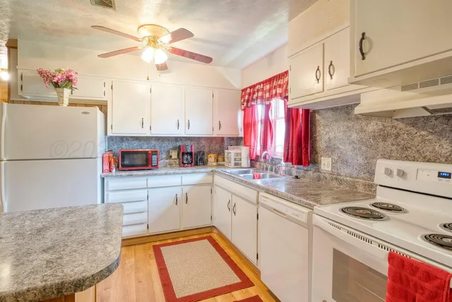 a kitchen with a refrigerator sink and white cabinets