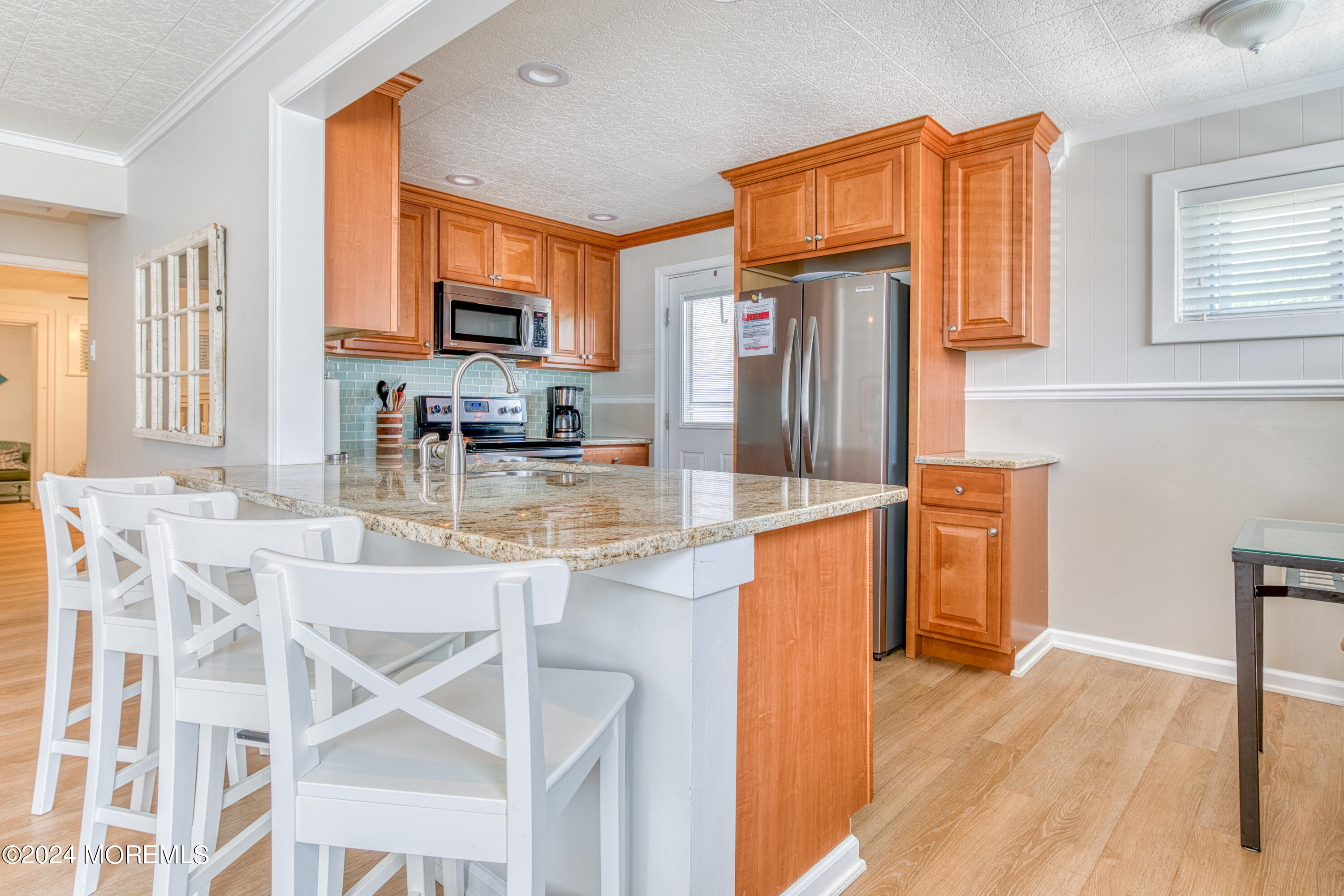 19 Via Ripa Way Sea Bright, NJ 07760 - Photo 6 of 37 a kitchen with stainless steel appliances granite countertop a refrigerator a stove a sink dishwasher and wooden cabinets with wooden floor