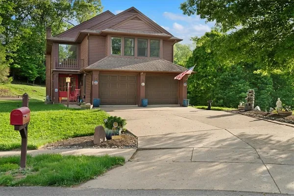 a front view of a house with a yard and potted plants