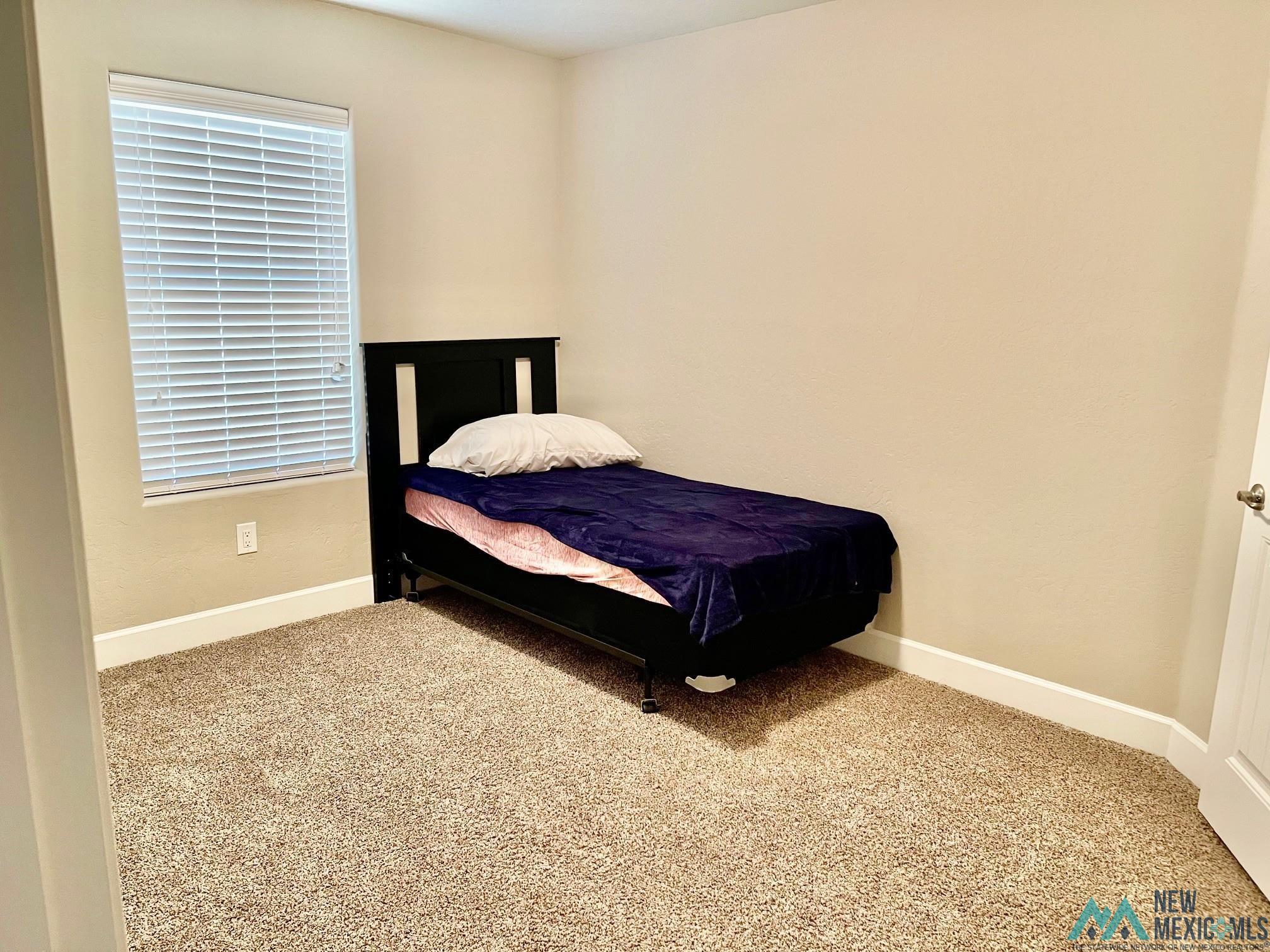 Carpeted bedroom with baseboards