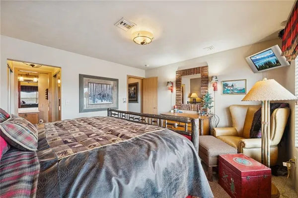 a spacious bedroom with a bed and a chandelier
