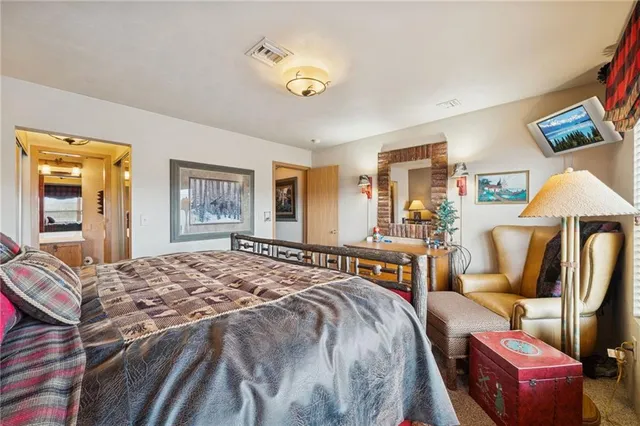 a spacious bedroom with a bed and a chandelier