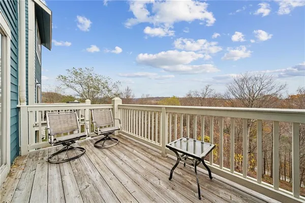 a view of a balcony with chairs and wooden floor
