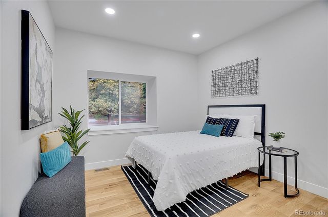 a bedroom with a large bed and a potted plant