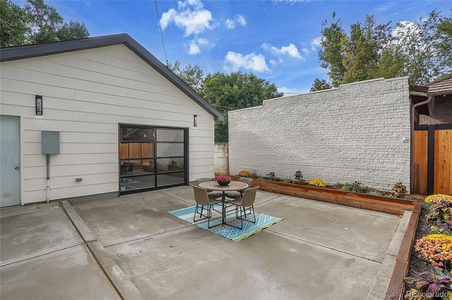 a view of a patio with a table and chairs and potted plants
